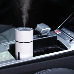 Car humidifier emitting steam inside a vehicle's cup holder.
