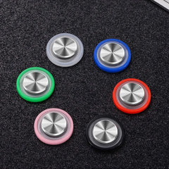 Set of colorful metal buttons with silver centers on a textured black surface