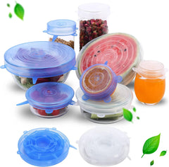 Silicone food covers in various colors on a white background with food items inside.