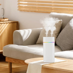 White humidifier emitting mist on a wooden table with a blurred living room background