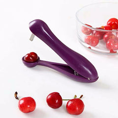 Purple cherry pitter with cherries on a white background