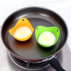 Two egg-shaped cookware clips on a frying pan with eggs inside.