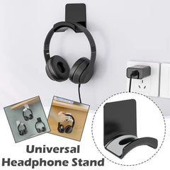 Black universal headphone stand holding a pair of headphones against a white wall.