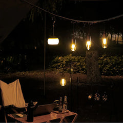 Outdoor setting with string lights hanging above a table with drinks and a chair.