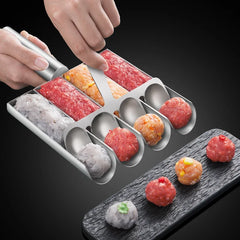 Metallic meatball maker with various colored ground meats on a dark surface