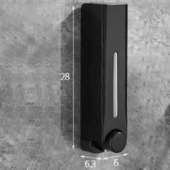 Black soap dispenser on a gray concrete surface with measurements indicated.