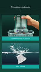 Hand holding a transparent dustbin with water splashing on a green background