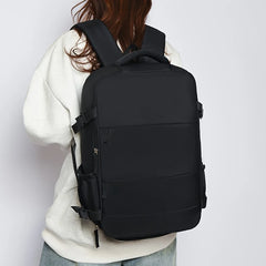 Person wearing a black backpack on a plain background