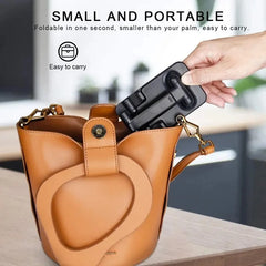 Brown leather bag with a black phone holder attached, held by a hand.