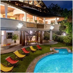 Luxury villa with a pool and lounge chairs at night