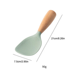 Green silicone spoon with wooden handle and measurements on a white background