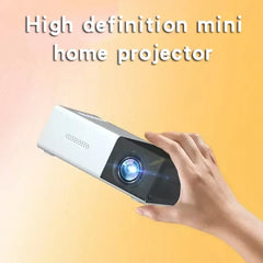 Hand holding a high definition mini home projector against a yellow background