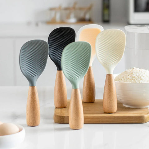 Set of five silicone kitchen utensils with wooden handles on a kitchen counter.