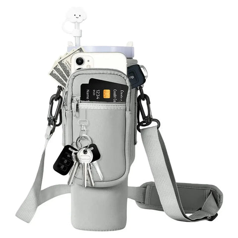 Gray crossbody bag with various items including a phone, cards, and keys on a white background