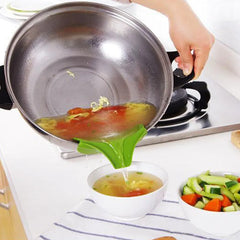 Stainless steel pot with a green ladle pouring soup into a bowl on a kitchen counter.