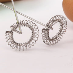 Pair of silver spiral hoop earrings on a light background