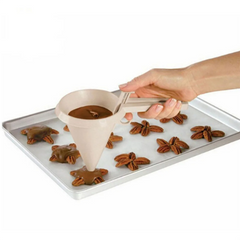Person using a funnel to fill star-shaped cookie molds with chocolate on a baking tray.