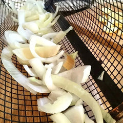 Sliced onions on a wire rack over a wooden surface