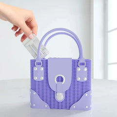 Purple handbag with white polka dots held by a hand against a light background