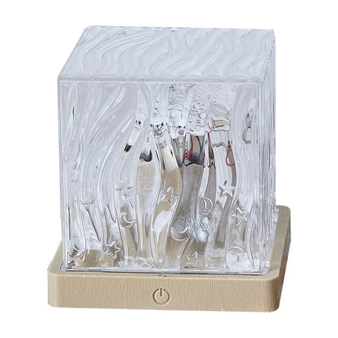 Clear glass product with engraved designs on a beige base against a white background