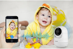 Baby in yellow outfit with smartphone and security camera, showing video call on screen.