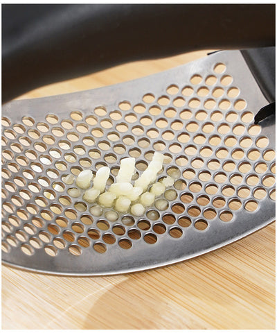 Metal grater with holes on a wooden surface