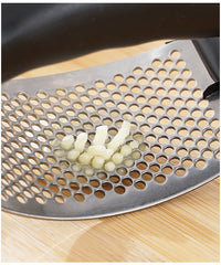 Metal grater with holes on a wooden surface