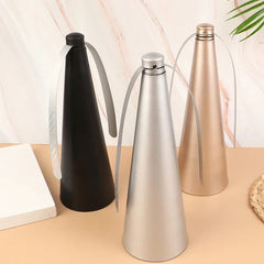 Three insulated bottles in black, silver, and gold on a beige surface with a light background.