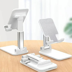 Set of white adjustable phone stands on a wooden surface with a blurred background