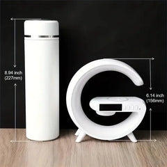 White thermos and digital clock with measurements on a black background