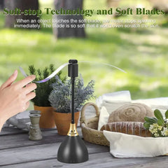 Black soft-stop technology device on a table with plants and a hand holding a ribbon.