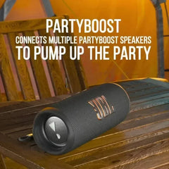 Black PartyBoost speaker on a wooden surface with promotional text.