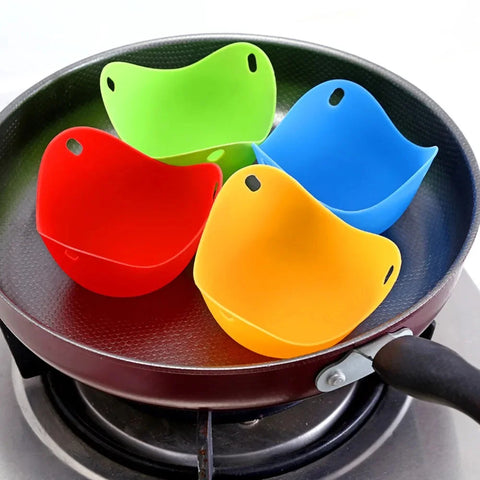 Colorful silicone poacher cups on a frying pan over a stove