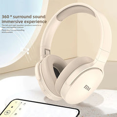 Beige headphones with 'mi' logo on a light surface, accompanied by a smartphone.