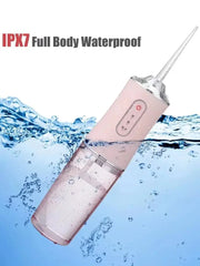 Pink dental water flosser with water splashes on a blue background, featuring IPX7 full body waterproof text.