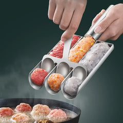Metallic meatball maker with colored meatballs being used to form meatballs in a pan.