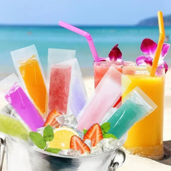 Colorful popsicles and drinks with straws on a beach setting
