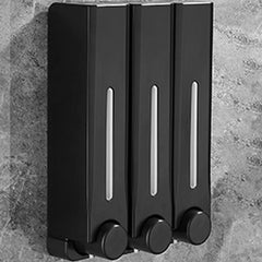 Black soap dispenser with three compartments on a gray stone background