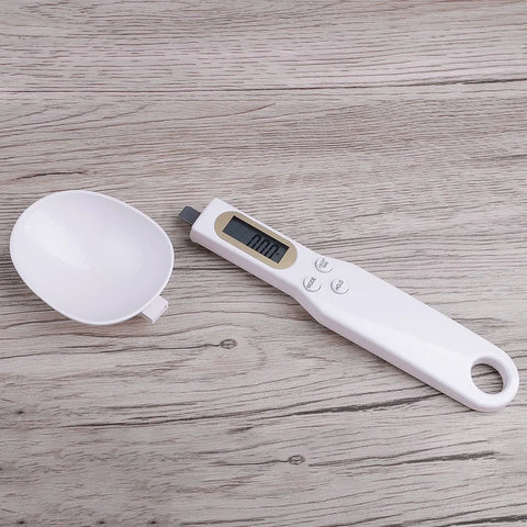 Digital kitchen scale with a white bowl on a wooden surface